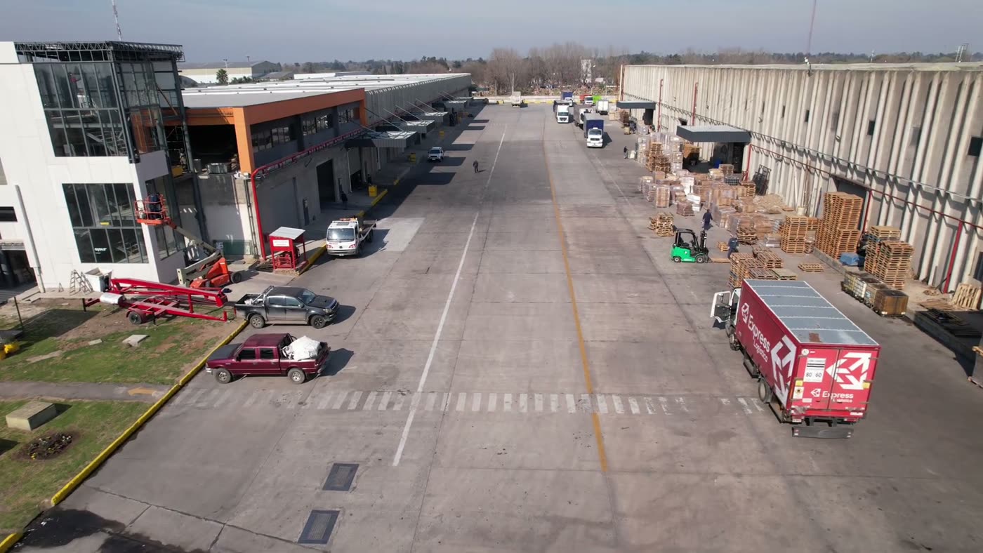 Dársenas de carga con camiones estacionados y pallets sobre la playa