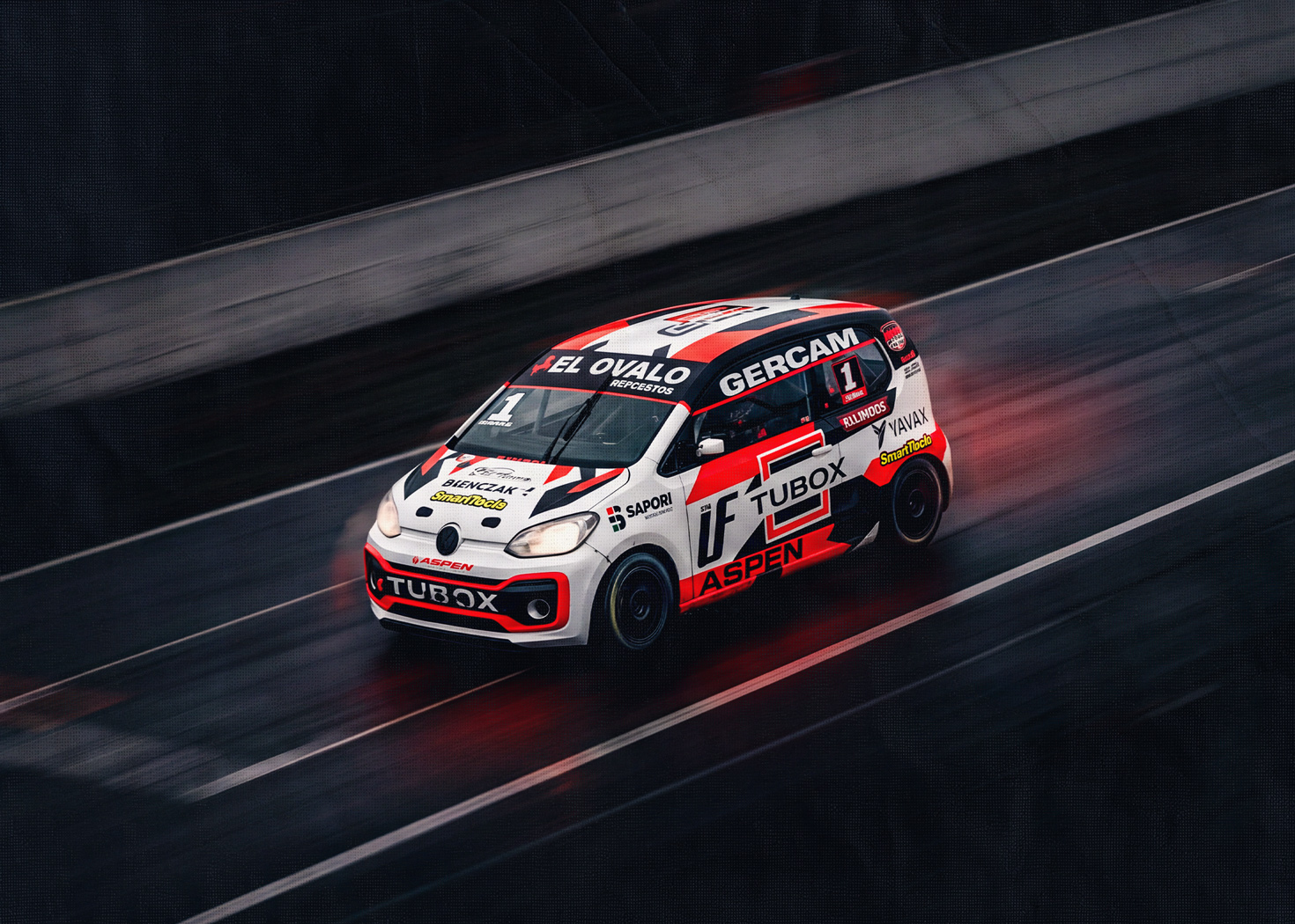 Auto de competición ploteado con la marca TuBox corriendo en una pista mojada